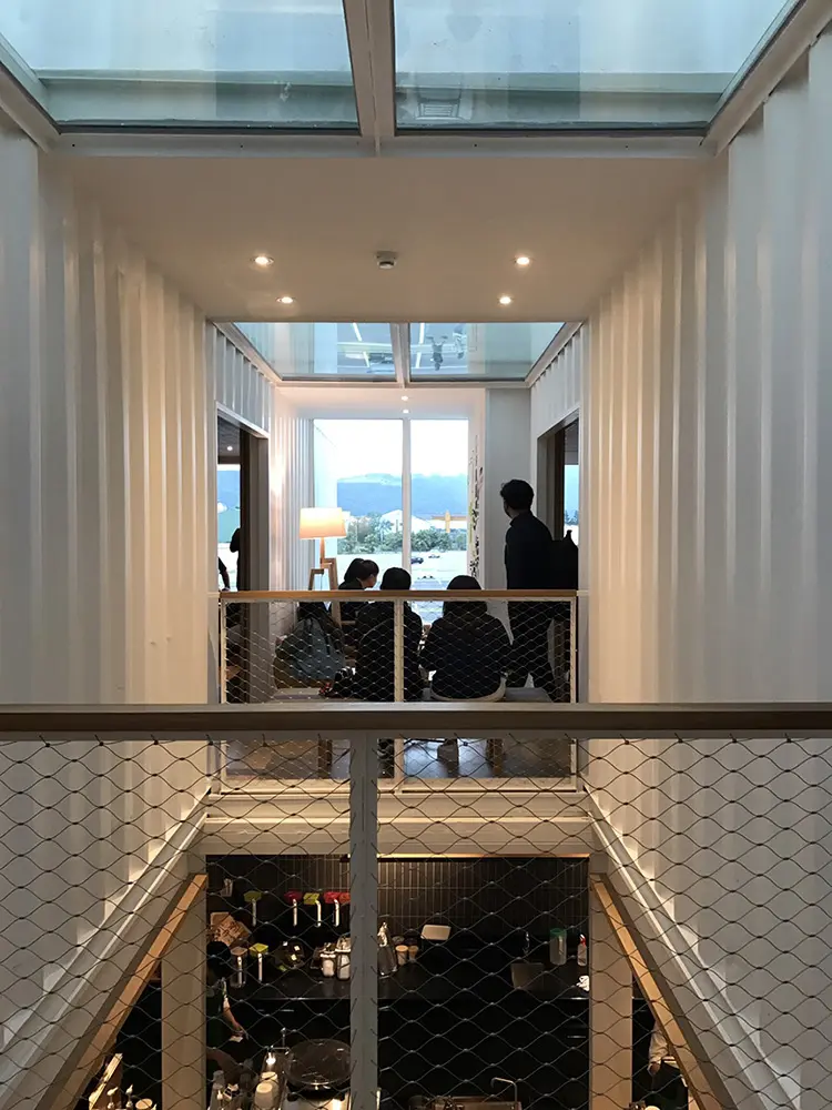 Interno al piano superiore con vista sulla baia di Hualien e bancone bar al piano sottostante protetto da rete metallica