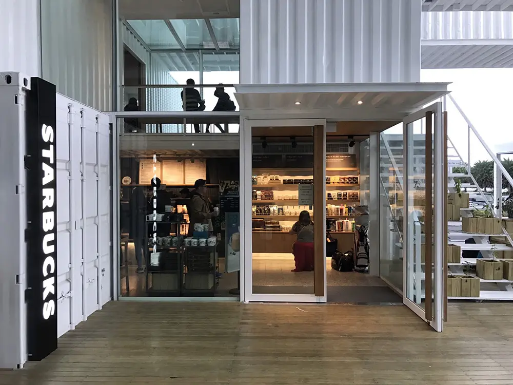 Ingresso dello Starbucks Hualienbay Store ricavato in un container con insegna STARBUCKS e scala esterna