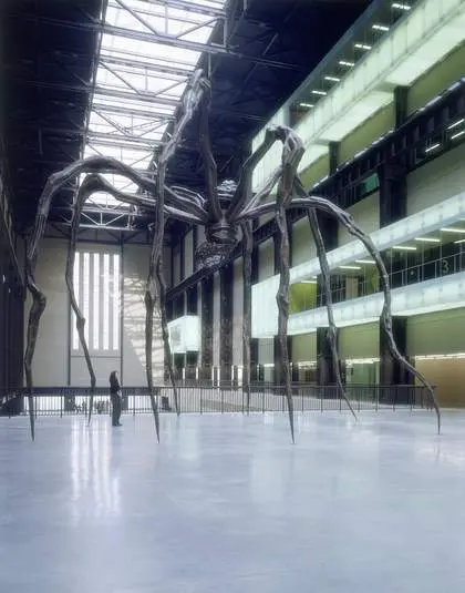 Il ragno Maman di Louise Bourgeois visto dal basso nella Turbine Hall della Tate Modern, con una persona in piedi tra le zampe a dare la misura della scala