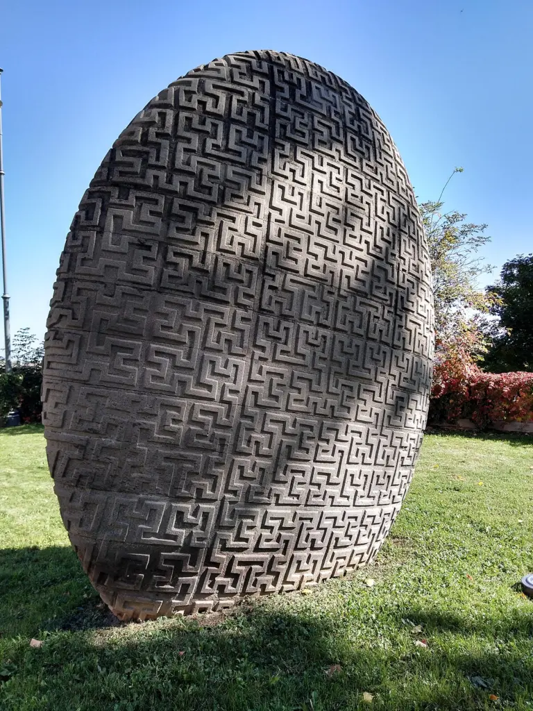 Il monumento a Giuseppe Peano sui bastioni di Cuneo, un uovo di pietra vulcanica inciso con il motivo della curva che riempie il piano