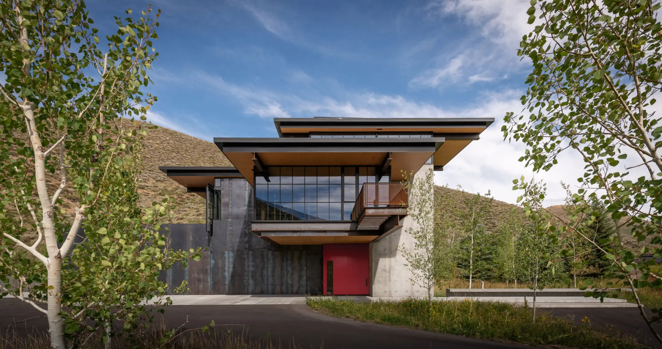 Facciata di Sky View Residence tra i pioppi, con la porta d'ingresso laccata di rosso