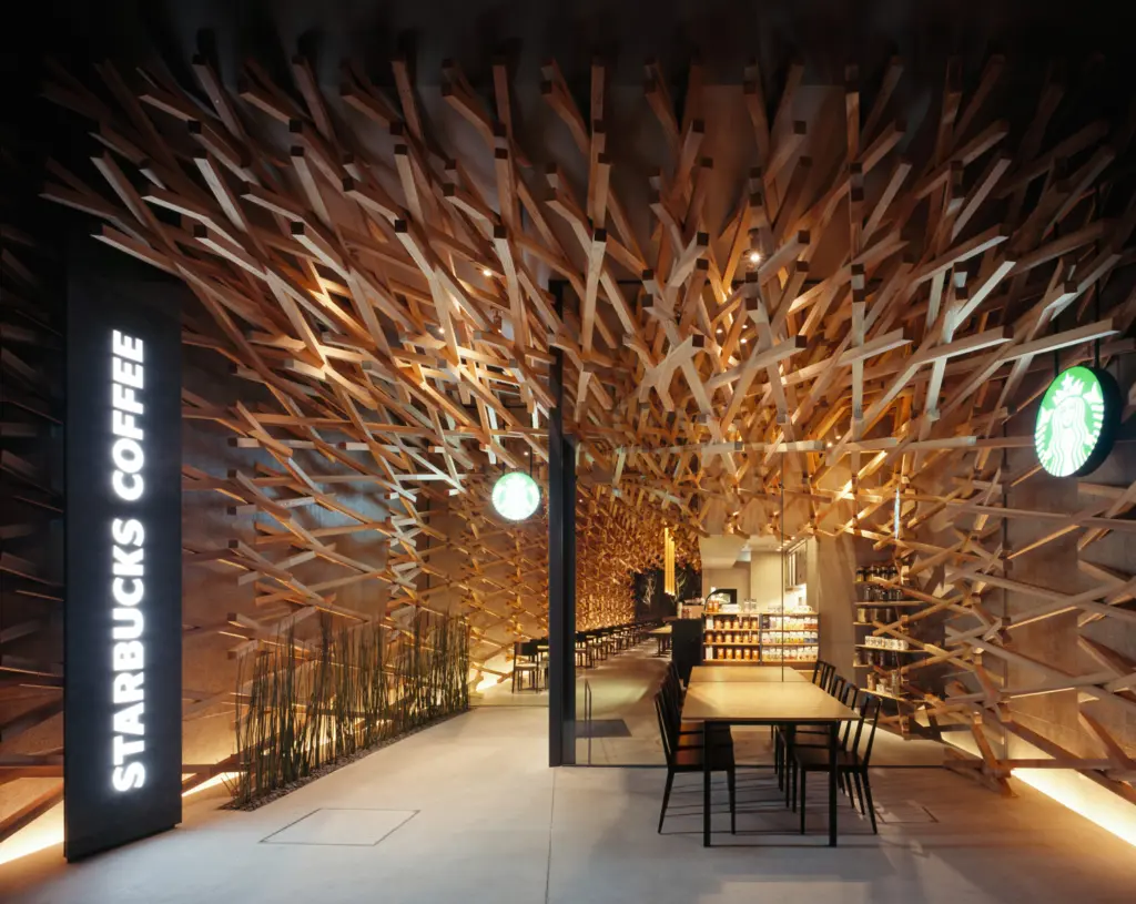 Interno del negozio Starbucks di Dazaifu con il soffitto e le pareti interamente rivestiti dall'intreccio di listelli di cedro