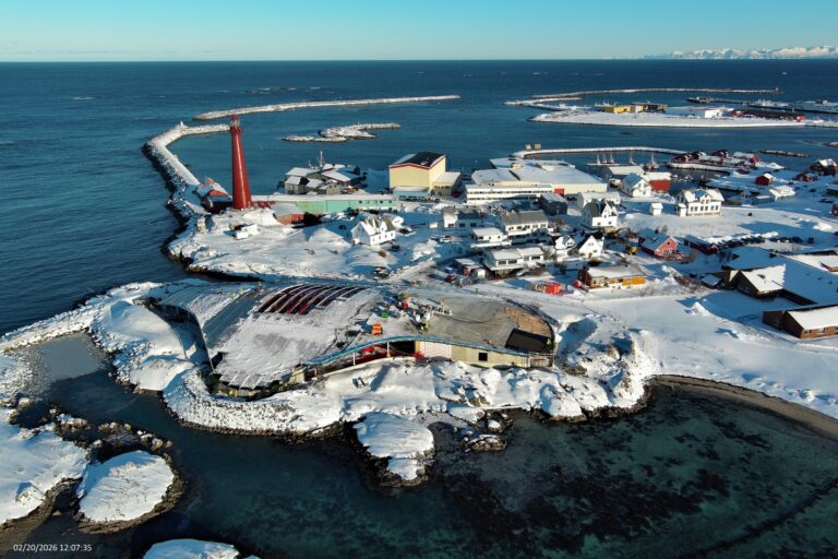 Vista aerea del cantiere di The Whale ad Andenes, con il faro rosso e il tetto-collina innevato