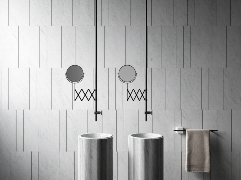 Bagno rivestito con il sistema Tratti di Elisa Ossino per Salvatori, lastre in Bianco Carrara scandite da bacchette metalliche nere