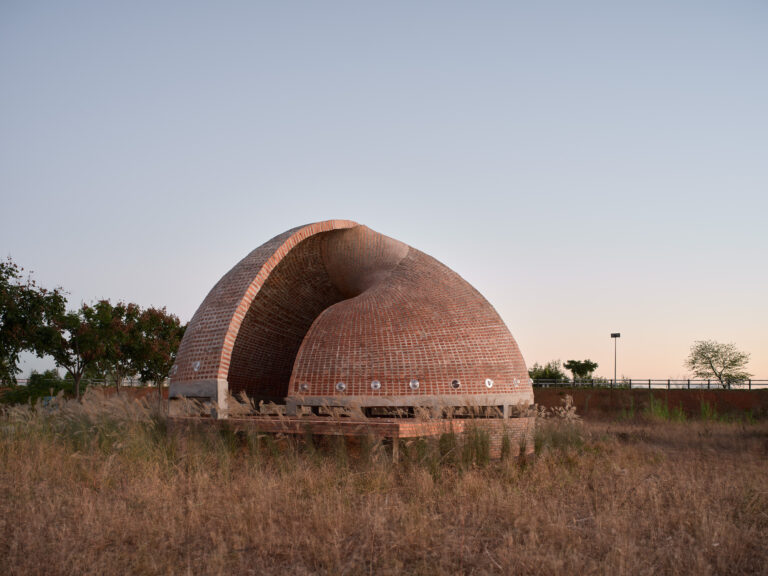 Twisted Brick Shell Library di HCCH Studio a Longyou, vista d'insieme al tramonto, guscio di mattoni ritorto