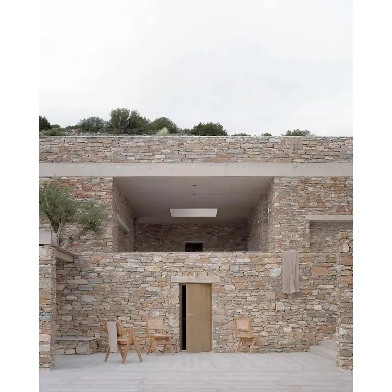 Facciata in pietra della casa Fysika a Sifnos, soglia d'ingresso tra due volumi