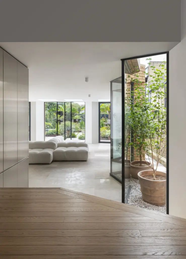Soggiorno di W House aperto su una piccola corte con alberi in vaso